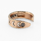 mixed-metal rings with crescent moon designs and TRUST engraved inside, each featuring adjustable bands, are shown from different angles.
