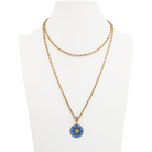 Gold necklace with a blue pendant on a mannequin bust against a white background