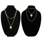 Two chain necklaces with round pendants: one gold with LISTEN adorned in plated brass and small beads, the other gold featuring a face design. Each piece exudes charm, enhanced by subtle crystal accents.