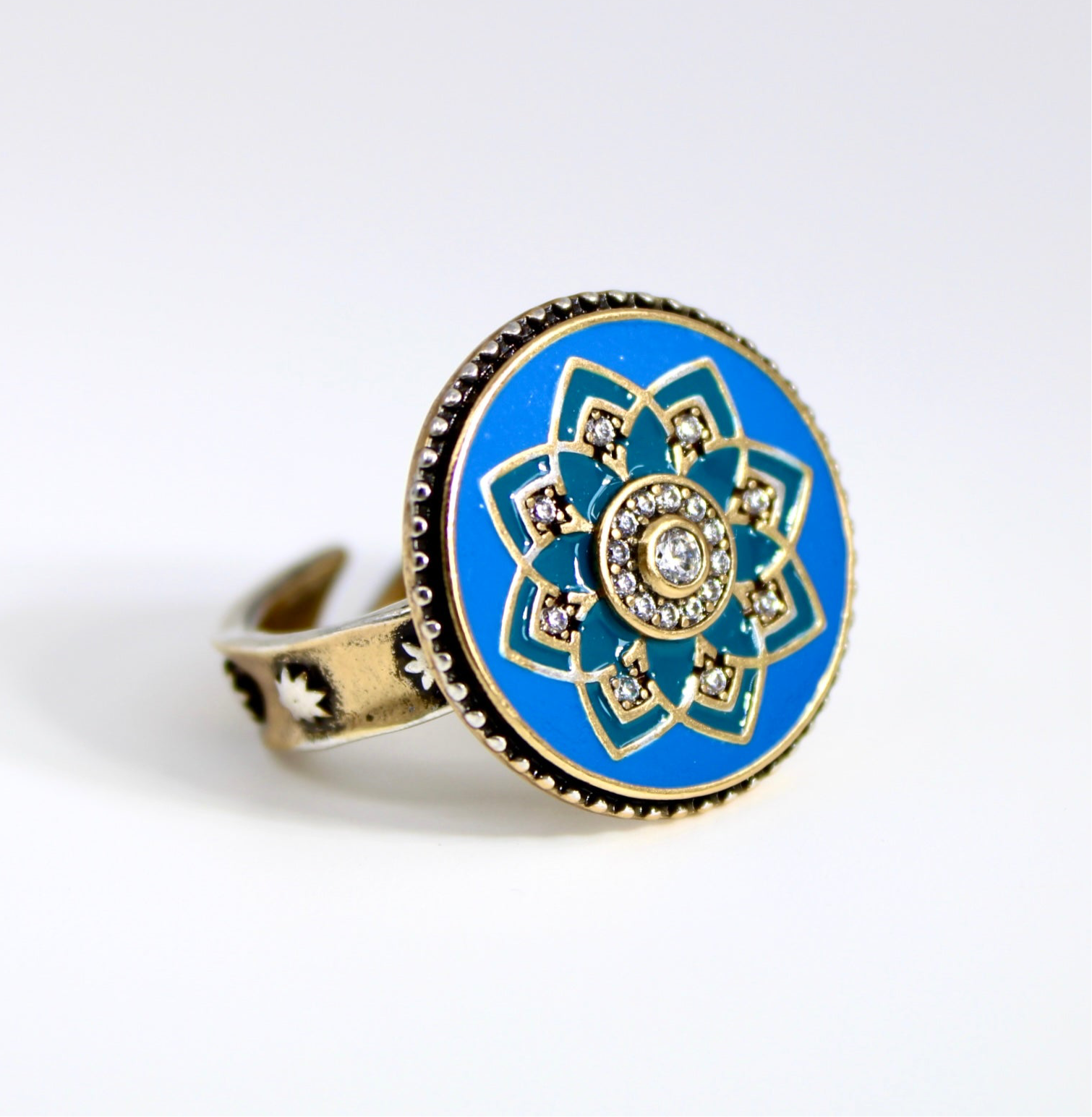 Ring with blue floral design and gold accents on a white background