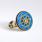 Ring with blue floral design and gold accents on a white background