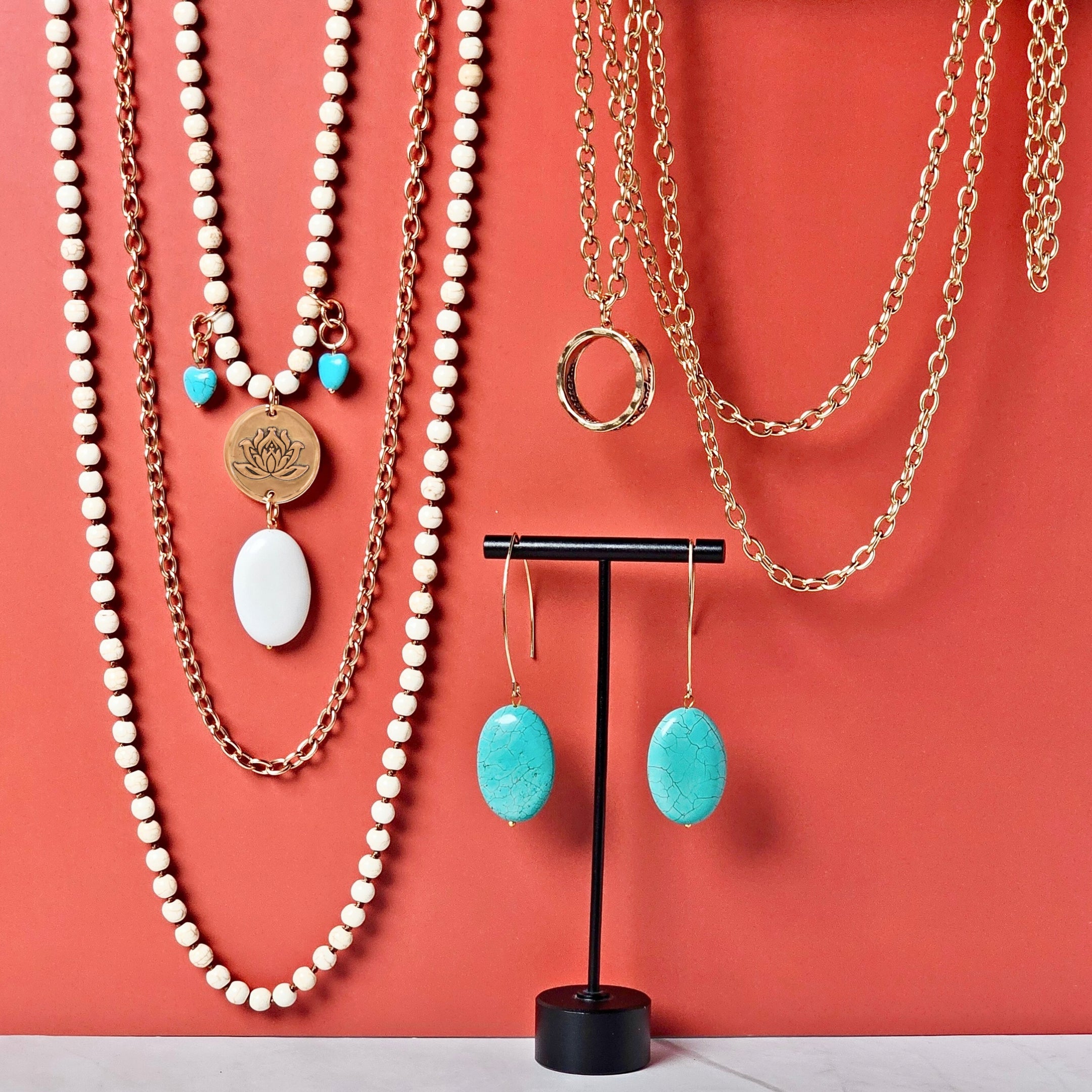 Jewelry set including necklaces and earrings on a coral background