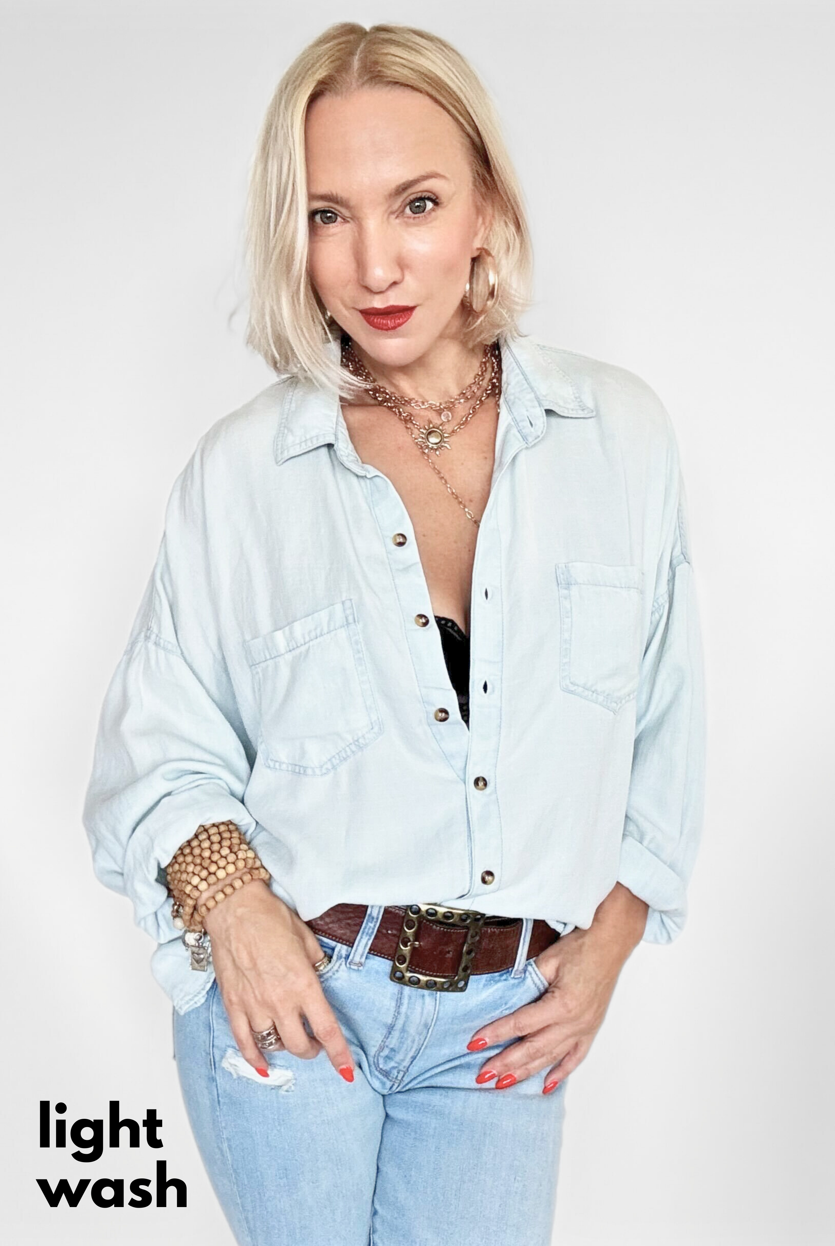 Woman wearing a light wash denim shirt and jeans on a white background
