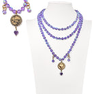 Purple beaded necklace with heart-shaped charms on a mannequin bust against a white background