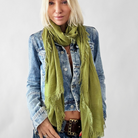 Woman wearing a green scarf and denim jacket on a white background