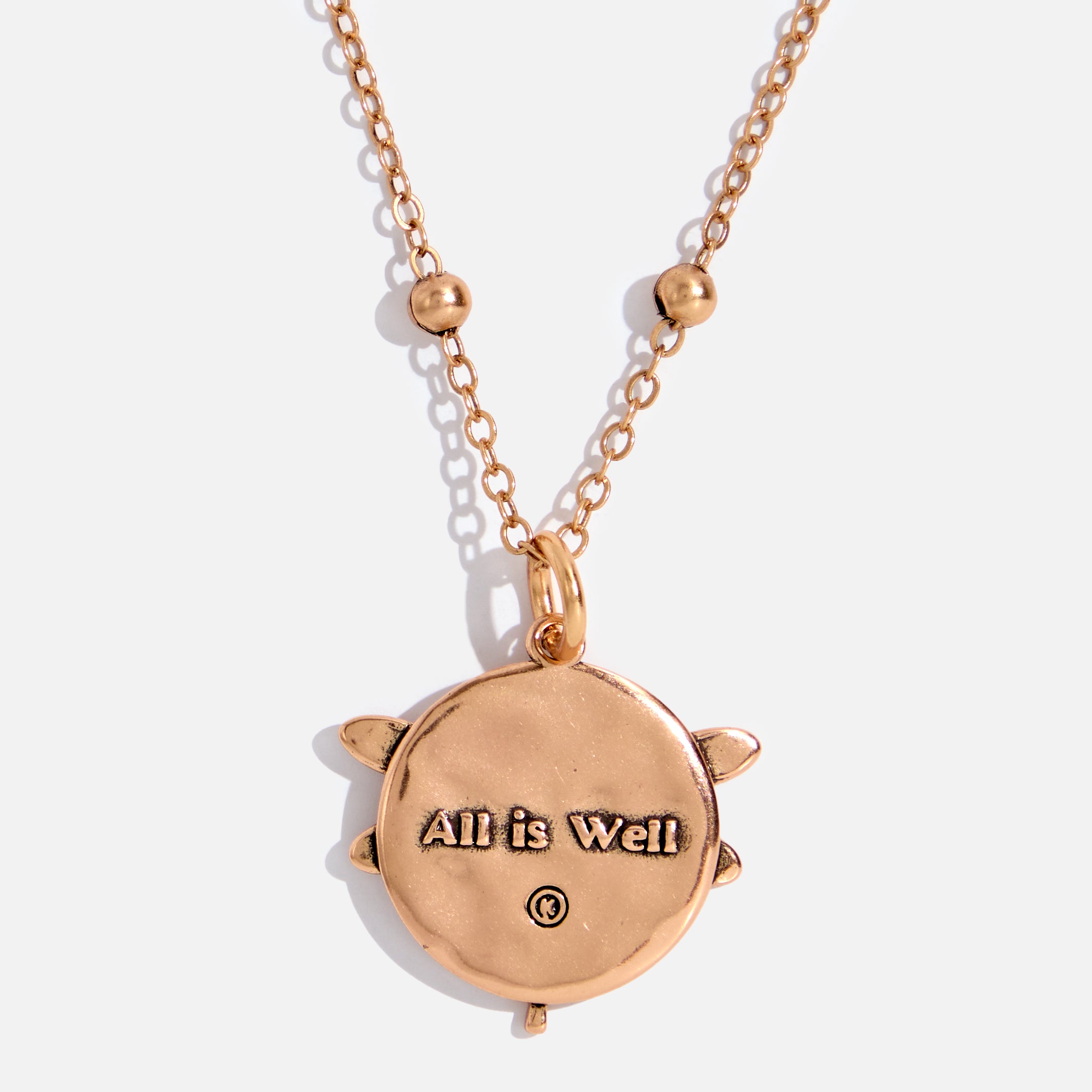 dragonfly pendant detail in gold and silver with message on back reads "all is well"