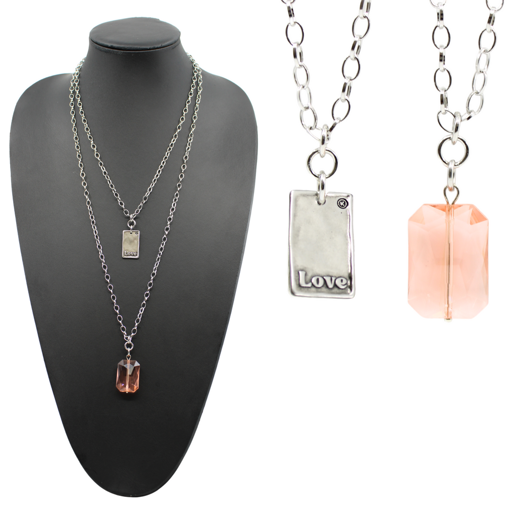 A black jewelry display showcases two versions of an elegant chain necklace: one features a peach crystal stone pendant, while the other flaunts a silver LOVE pendant. Separate close-ups capture the intricate beauty of both pendants.