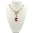 Gold necklace with a red pendant on a white mannequin bust.