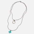 Silver necklace with a blue pendant on a white background