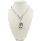 Silver necklace with a rectangular crystal pendant on a mannequin bust.