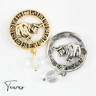 Two necklaces with gold and silver chains, featuring circular pendants with zodiac signs, and faceted crystal quartz accents.