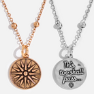Two dainty necklaces with round pendants, one with a gold finish and a star design, and the other with a silver finish and text 'This too shall pass.